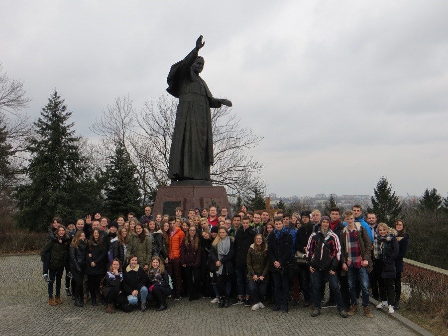 Na zdjęciu duża grupa młodzieży pod pomnikiem Jana Pawła II.