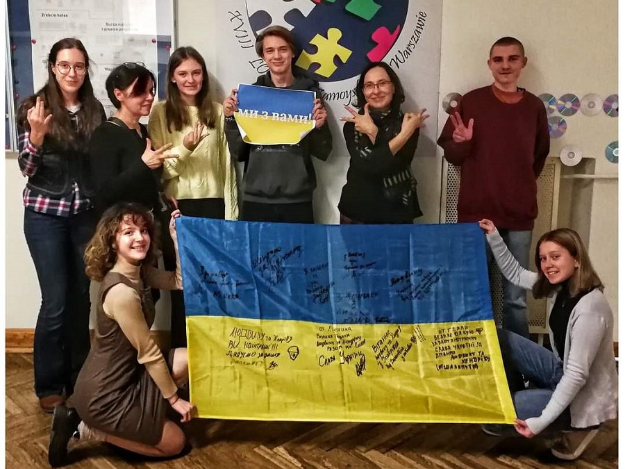 Na zdjęciu grupka uczniów trzyma białoruska flagę.