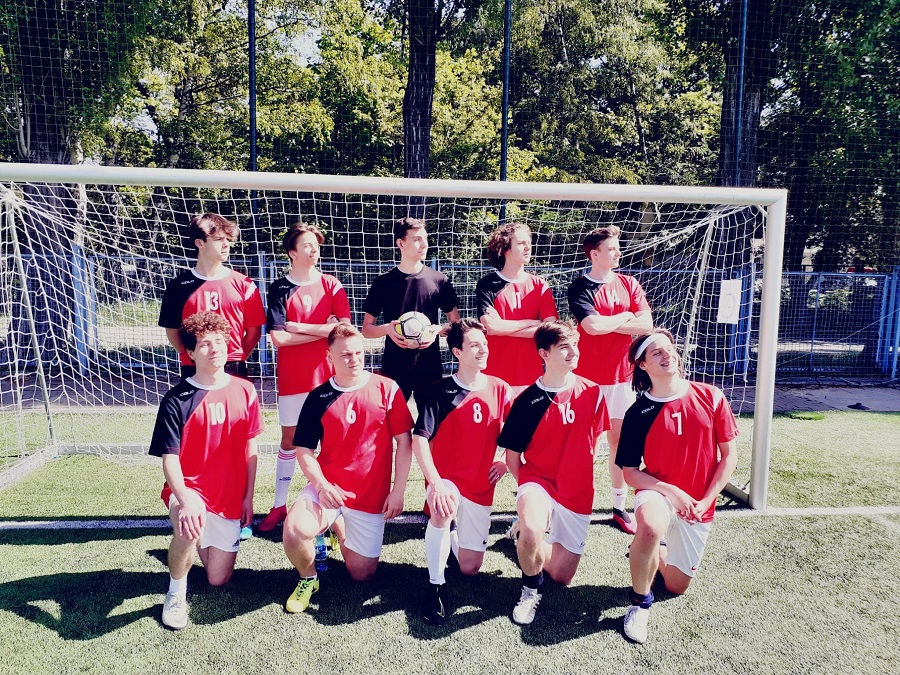 Na zdjęciu drużyna piłkarska w czerwonych koszulkach.