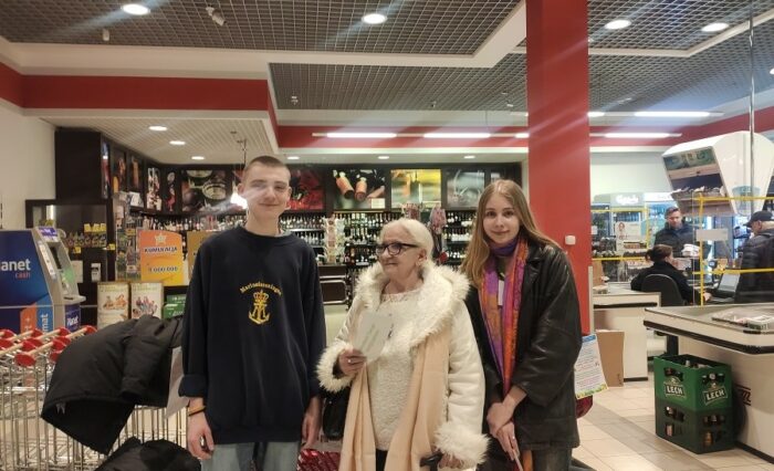 Na zdjęciu dwoje uczniów i osoba dorosła w supermarkecie.