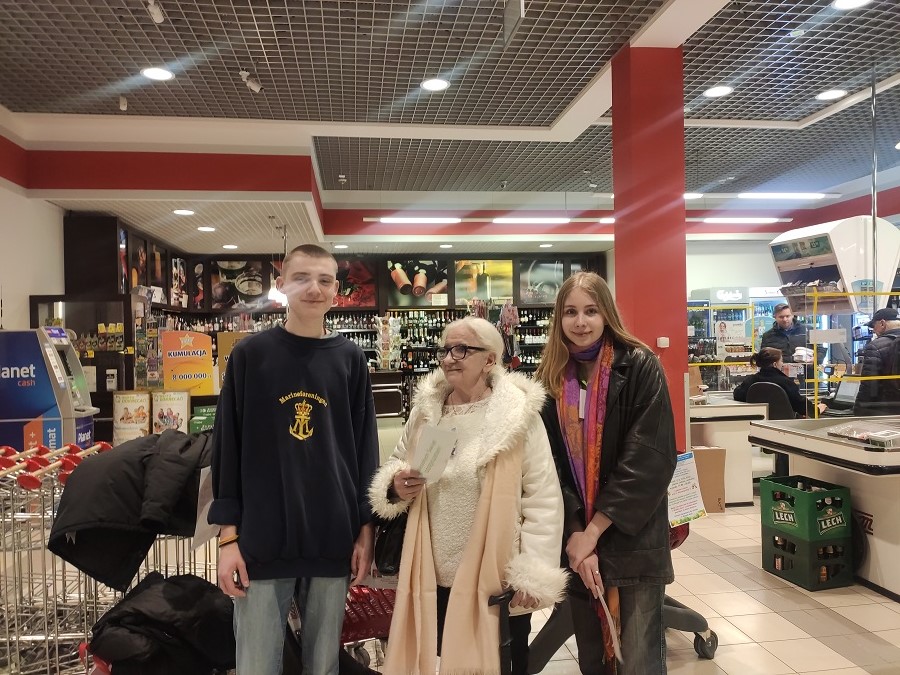 Na zdjęciu dwoje uczniów i osoba dorosła w supermarkecie.