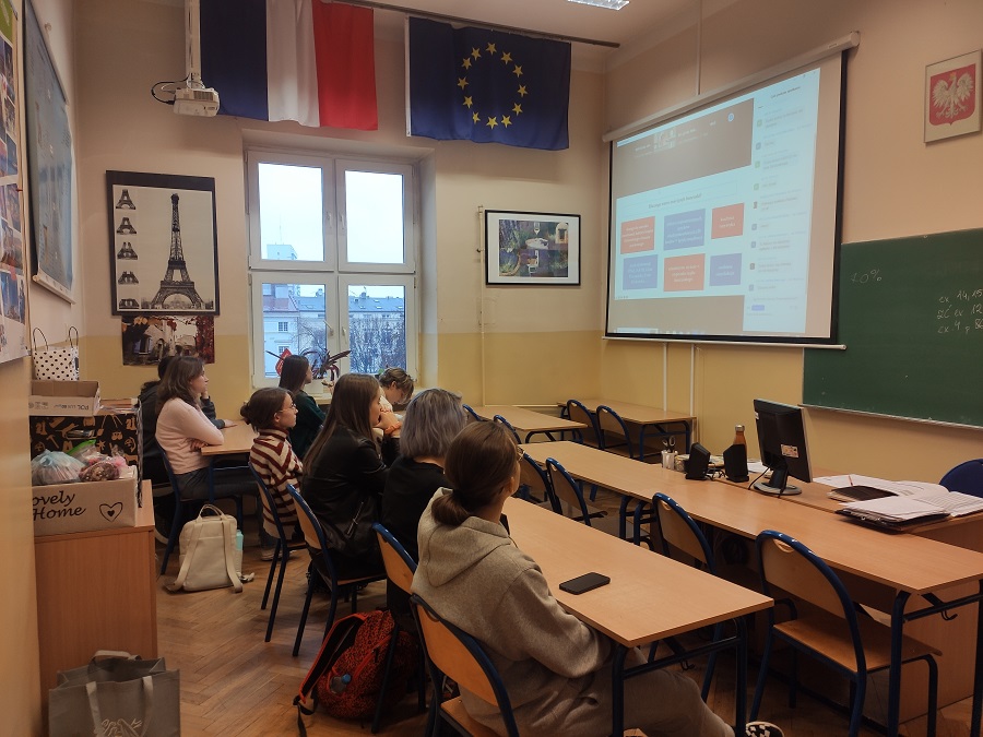 Na zdjęciu uczniowie w sali lekcyjnej słuchają wykładu online.