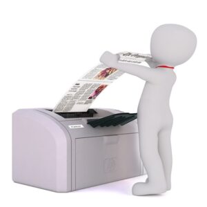 Na zdjęciu ludzik stojący przy drukarce.