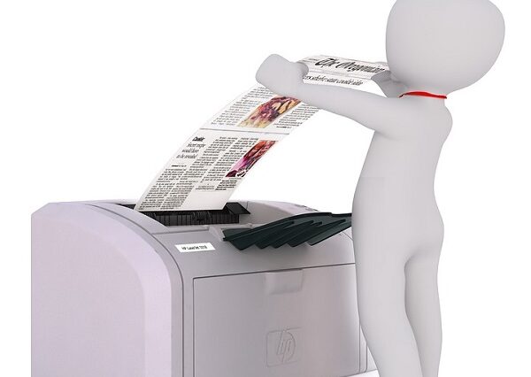 Na zdjęciu ludzik stojący przy drukarce.
