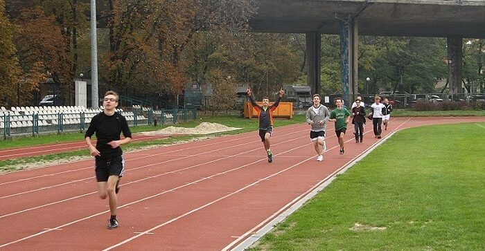 Na zdjęciu grupka młodzieży biegnie na bieżni.