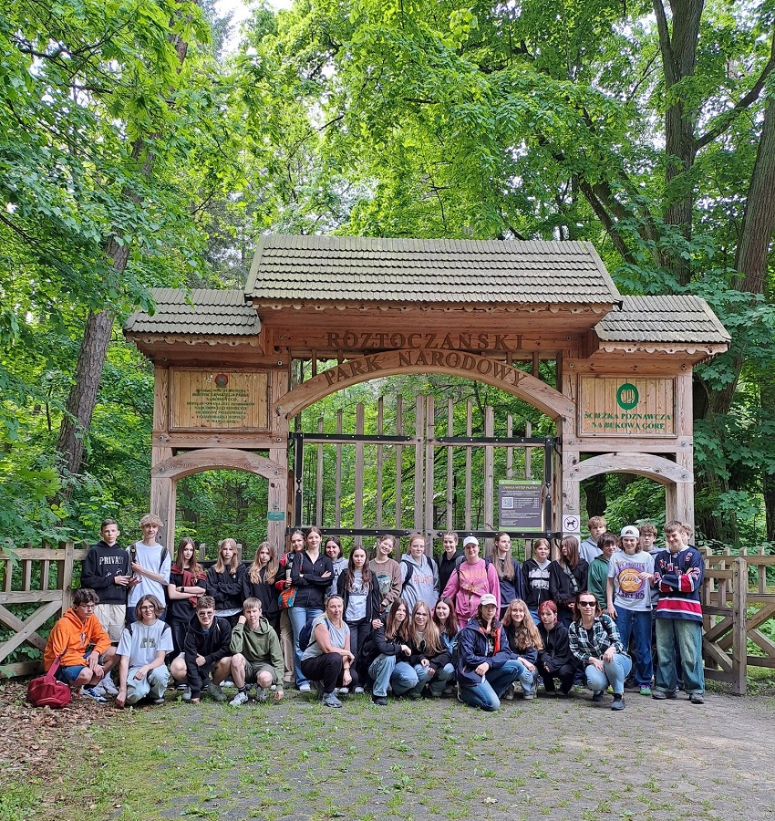 Na zdjęciu klasa przy drewnianej bramie do Roztoczańskiego Parku Narodowego.
