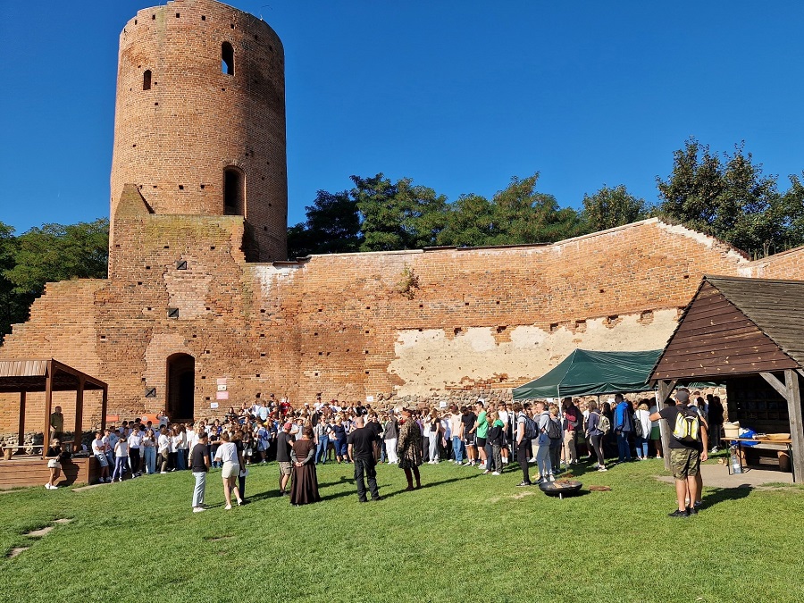 Na zdjęciu zamek w Czersku i zgromadzona przy nim grupa młodzieży.