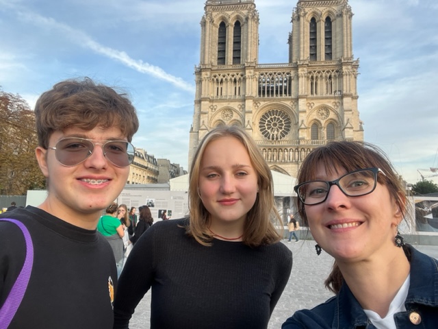 Na zdjęciu uczniowie wraz z nauczycielką na tle katedry Notre Dame.