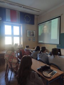 Na zdjęciu uczniowie w sali lekcyjnej uczestniczą w wykładzie online. 
