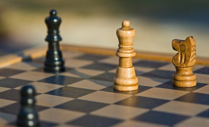 Na zdjęciu szachownica z kilkoma pionkami.